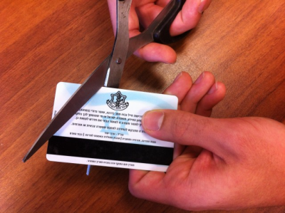 A soldier cutting his identification card at the end of his military service