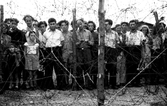 Refugees peer out from behind barbed wire at the Poppendorf camp.
CHRIS BUTLER/STARS AND STRIPES